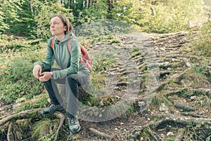 Female hiker resting and contemplating in forest