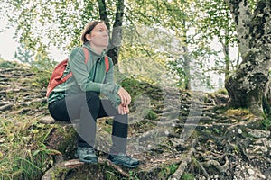 Female hiker resting and contemplating in forest