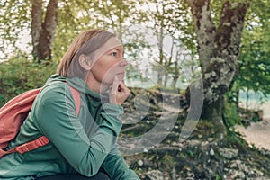 Female hiker resting and contemplating in forest