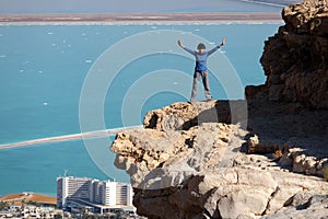 Female hiker on rock cliff in Judea desert.