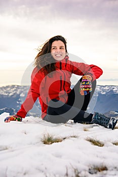 Female hiker sitting on snow covered mountain top