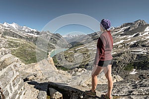 Female hiker standing on rock of mountain top enjoying view of v