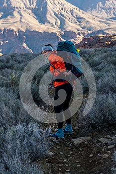 Female Hiker Struggling To Reach Something In Her Pack