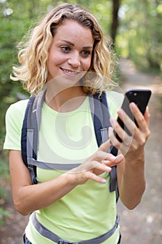 female hiker text messaging on mobile phone