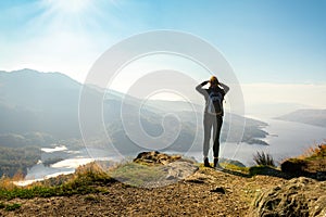 Female hiker on top of the mountain enjoying valley view