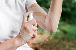 Female hiker using antiseptic spray outdoors