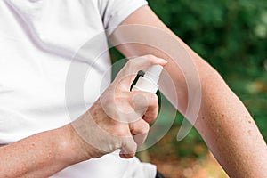 Female hiker using antiseptic spray outdoors