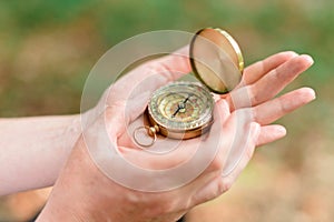 Female hiker using compass for navigation and orientation in forest