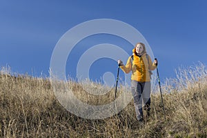Female hiker walks downhill and enjoys warm