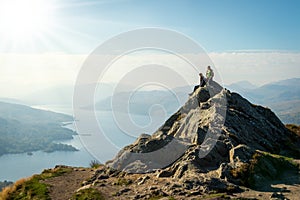 Female hikers on top of the mountain enjoying valley view