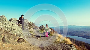 Female hikers on top of the mountain taking a break and enjoying a valley view