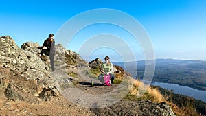 Female hikers on top of the mountain taking a break and enjoying a valley view