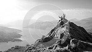 Female hikers on top of the mountain taking a break and enjoying a valley view