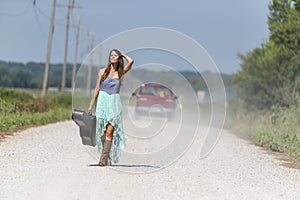 A Female Hitchhikes On A Dirt Road