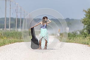 A Female Hitchhikes On A Dirt Road