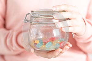 Female holding glass jar full of jelly beans