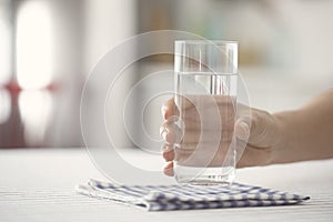 Female holding glass of water on kicthen table