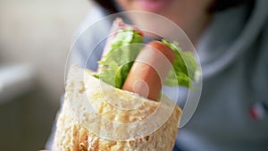 Female Holding in Hands a Bitten Juicy American Hot Dog with Sausages in Diner