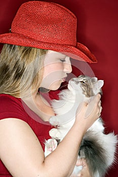Female holding and kissing cat