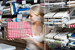 Female holding tablecloths in home textile boutique