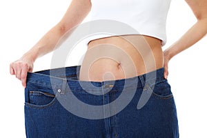 Female holds her old huge jeans, diet concept