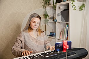 Female at home playing on synthesizer for followers