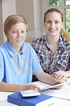 Female Home Tutor Helping Boy With Studies Using Digital Tablet