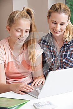 Female Home Tutor Helping Girl With Studies Using Laptop photo