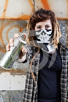 Female hooligan holding graffiti spray