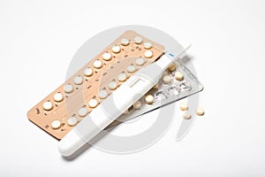 Female hormonal contraceptives and pregnancy test on a white background