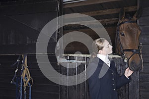 Female Horseback Rider With Horse In Stable