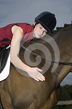 Female Horseback Rider Hugging Horse