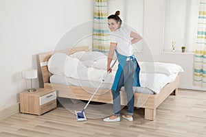 Female Housekeeper Mopping Hardwood Floor