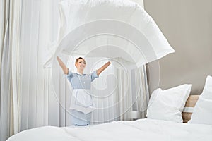 Female housekeeping worker making bed