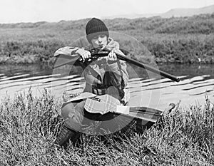 Female hunter with gun near river