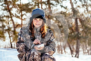 Female hunter preparing food with a portable gas burner in a win