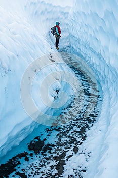 Female ice climbing guide exploring ice canyon on the Matanuska Glacier in Alaska