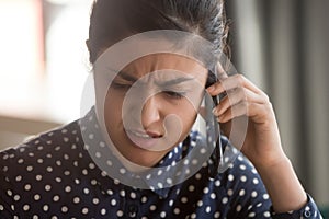 Female indian employee having unpleasant cellphone conversation