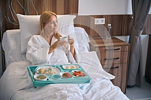 Female inpatient thinking about something during lunchtime in ward