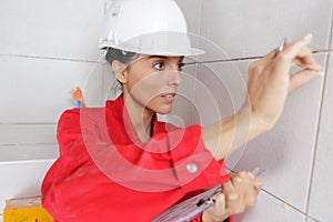 female inspector checking wall tiles