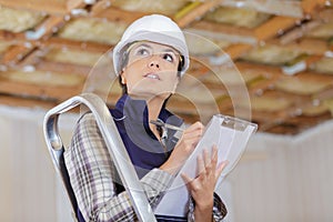 female inspector with clipboard inside renovation property