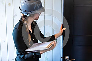 Female inspector reviews a room door