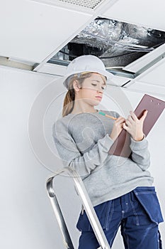 female inspector on stepladder