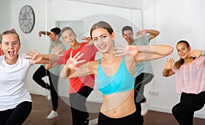 Female instructor fulfilling dance movements with teenagers