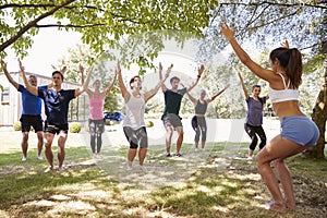 Female Instructor Leading Outdoor Yoga Class