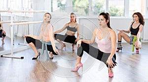 Female instructor performing graceful sass dance at group class