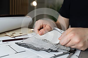 Female interior designer showing furniture fabric material samples to clients in a design studio.