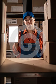Female inventory warehouse manager holding digital tablet computer with mock up blank