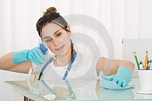 Female Janitor Cleaning Desk With Rag