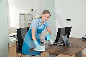 Female Janitor Cleaning Desk